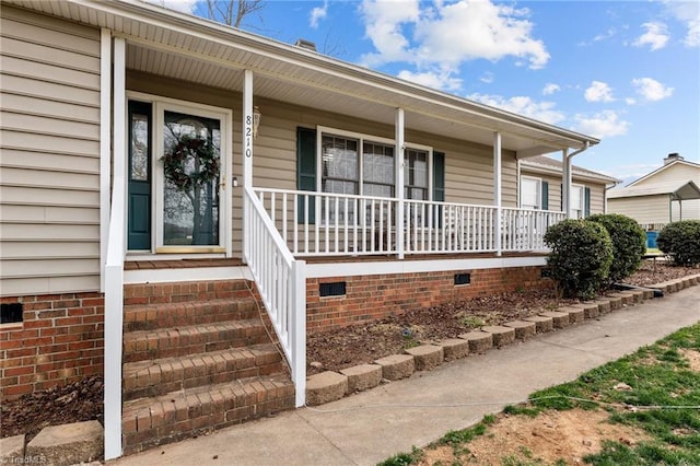 doorway to property with crawl space and a porch