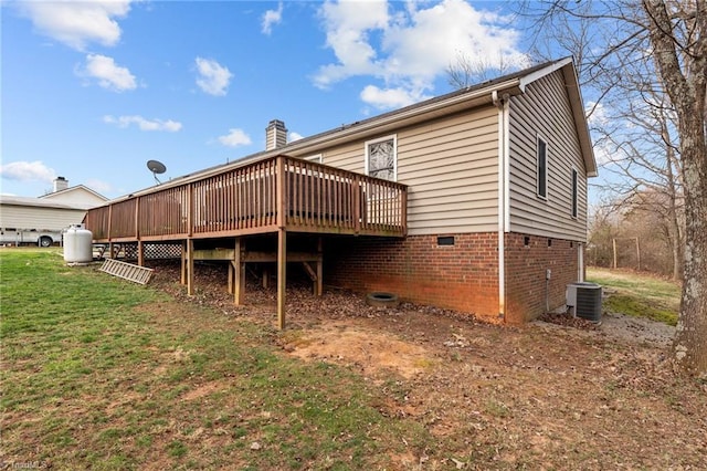 back of house featuring a wooden deck, central air condition unit, a lawn, and a chimney