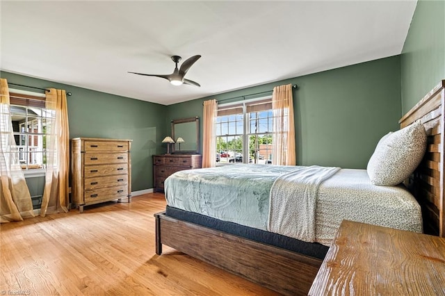 bedroom featuring wood finished floors, a ceiling fan, and baseboards