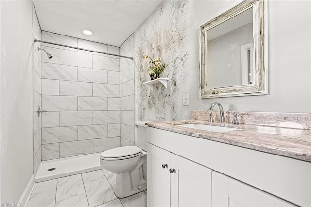 bathroom featuring marble look tiles, toilet, vanity, and tiled shower