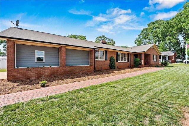 ranch-style house with brick siding, a front yard, and a chimney