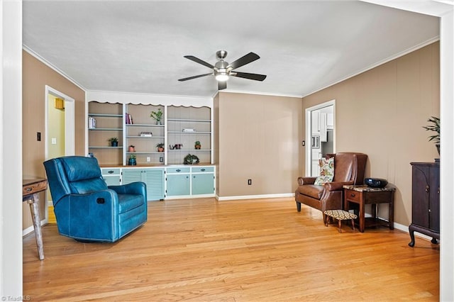 living area with crown molding, ceiling fan, light wood-style flooring, baseboards, and built in shelves
