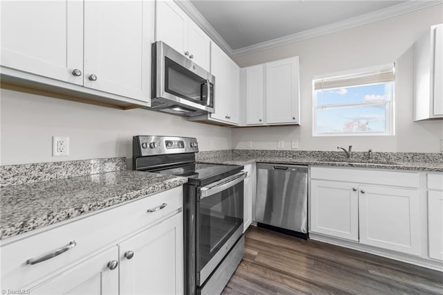 kitchen featuring crown molding, stainless steel appliances, white cabinetry, and light stone countertops