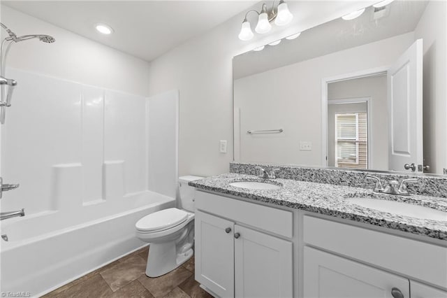 bathroom featuring double vanity, tub / shower combination, a sink, and toilet