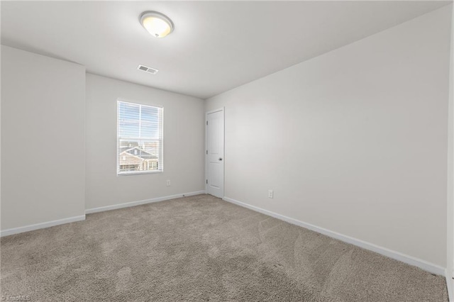 empty room with light carpet, visible vents, and baseboards