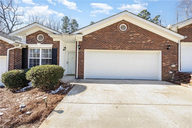 single story home featuring concrete driveway, brick siding, and an attached garage