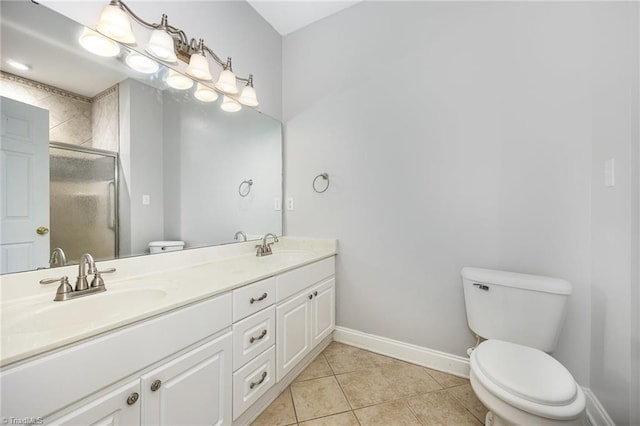 bathroom with tile patterned flooring, a shower stall, baseboards, and a sink