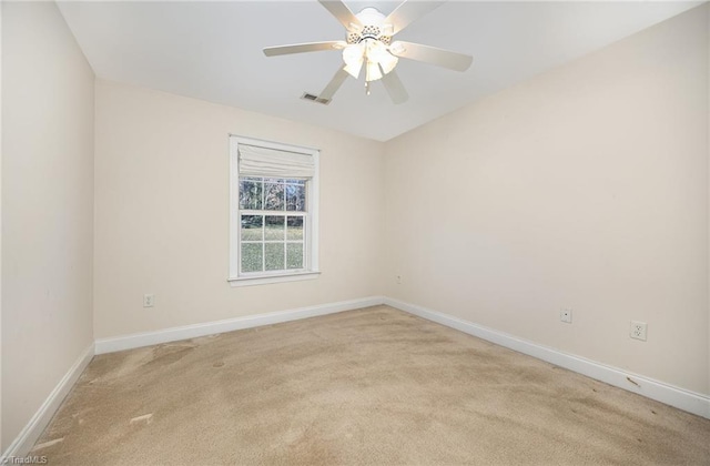 spare room featuring baseboards, a ceiling fan, and light colored carpet