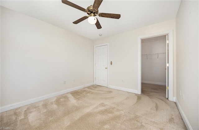 unfurnished bedroom with ceiling fan, light colored carpet, baseboards, a spacious closet, and a closet