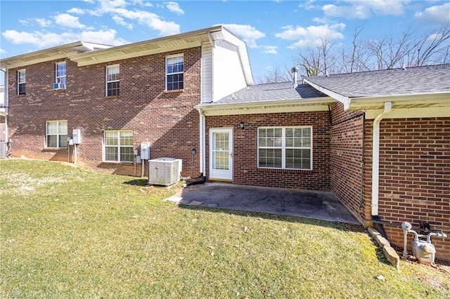 rear view of house featuring a shingled roof, a patio, a yard, central AC, and brick siding