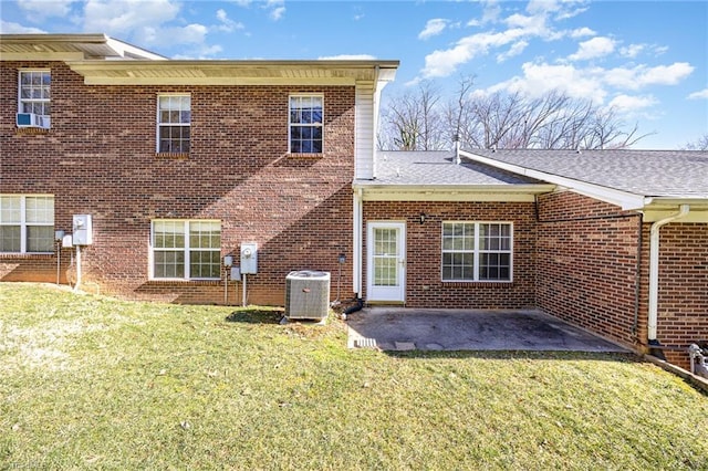 back of property with central AC unit, a lawn, a patio area, and brick siding