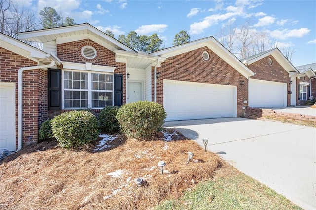 ranch-style home with a garage, concrete driveway, and brick siding