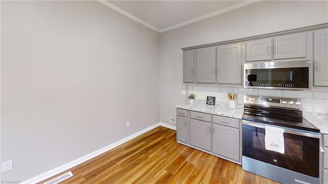 kitchen featuring appliances with stainless steel finishes, visible vents, crown molding, and gray cabinets