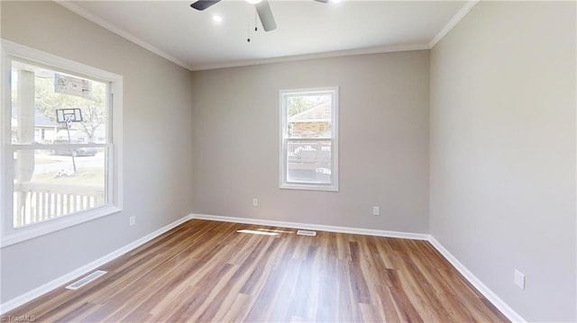 unfurnished room with wood finished floors, visible vents, a ceiling fan, and baseboards