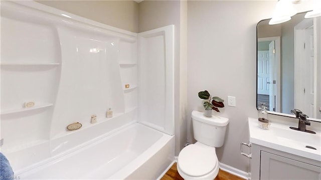 full bathroom with baseboards, shower / bathing tub combination, toilet, and vanity