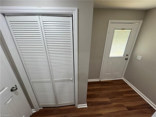 doorway to outside featuring dark wood-style flooring and baseboards