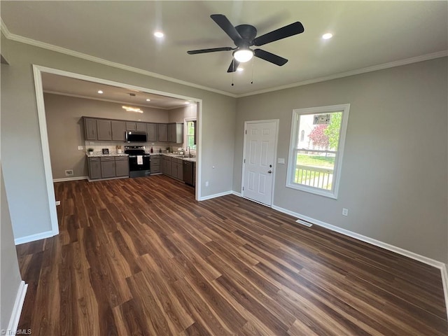 unfurnished living room featuring baseboards, a ceiling fan, dark wood-style flooring, and crown molding