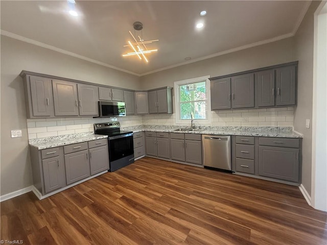 kitchen with dark wood-style floors, gray cabinetry, appliances with stainless steel finishes, and decorative backsplash