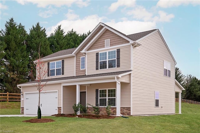 view of front of home with a garage, a front lawn, and covered porch