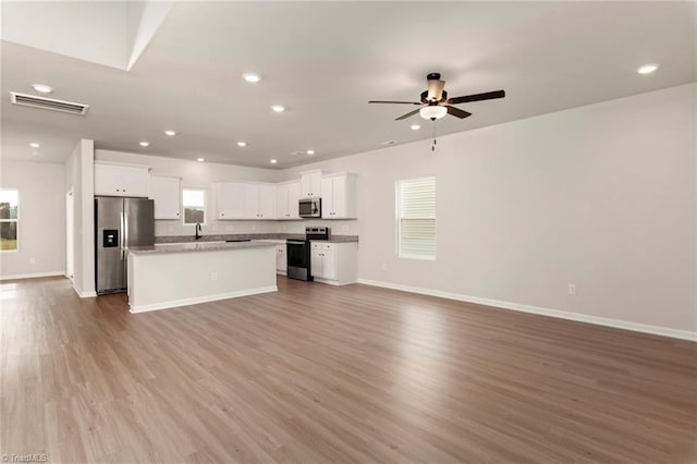 kitchen with light hardwood / wood-style flooring, ceiling fan, white cabinetry, stainless steel appliances, and a center island