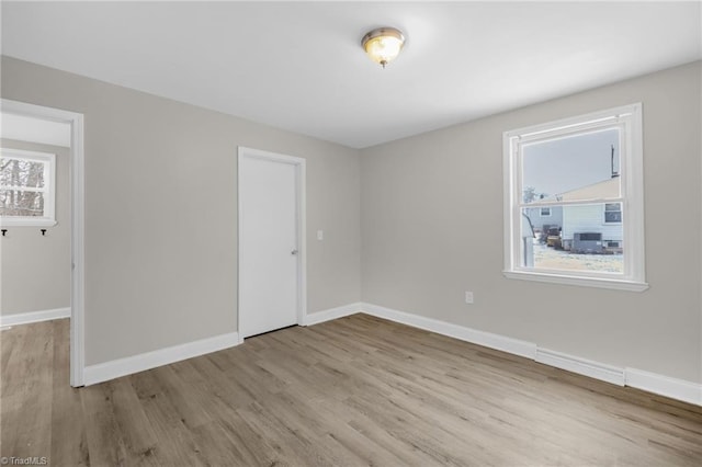 spare room with a wealth of natural light and light hardwood / wood-style flooring