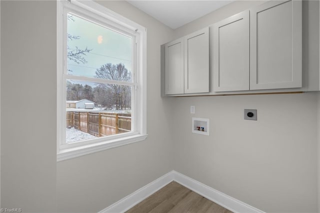 laundry area with washer hookup, hookup for an electric dryer, hardwood / wood-style flooring, and cabinets