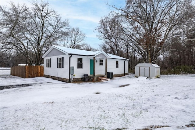 view of front facade with central AC unit and a shed