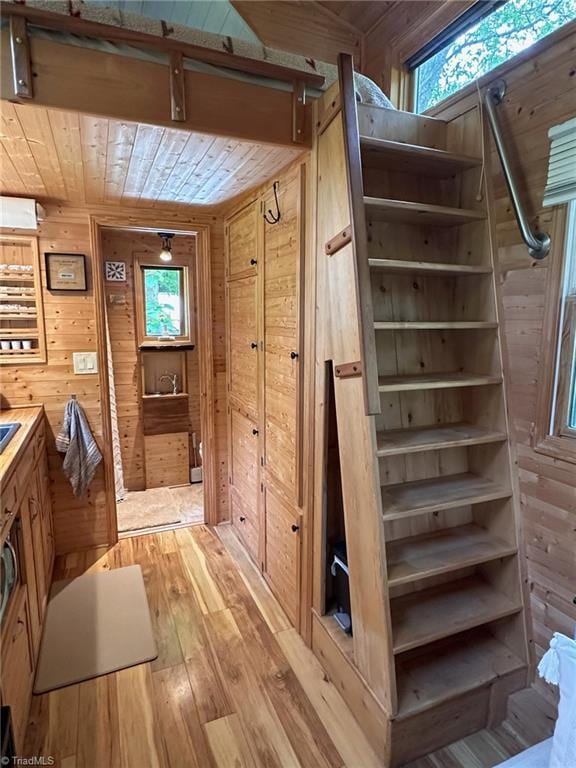 interior space with wood walls, wooden ceiling, and hardwood / wood-style flooring