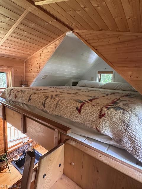 room details featuring wood walls, hardwood / wood-style floors, and wood ceiling