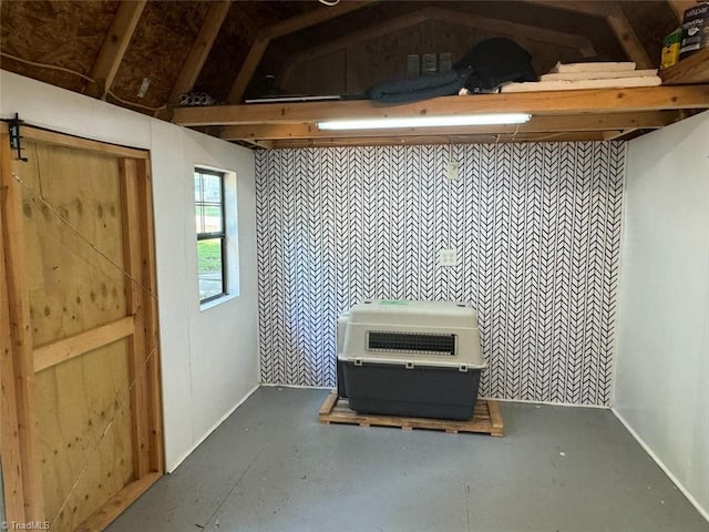 miscellaneous room with concrete floors, heating unit, and lofted ceiling