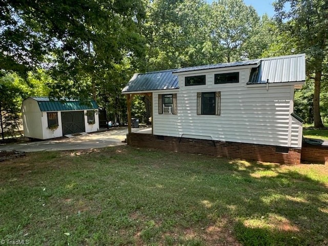 view of outdoor structure featuring a lawn and cooling unit