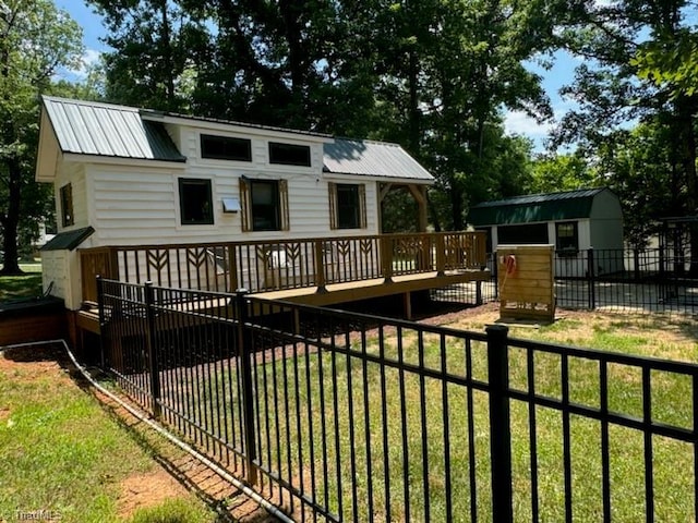 back of house with a lawn and a deck