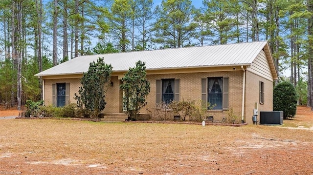 ranch-style house with cooling unit and a front lawn