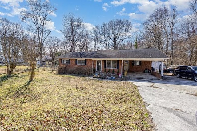 ranch-style home featuring aphalt driveway, a front yard, and brick siding