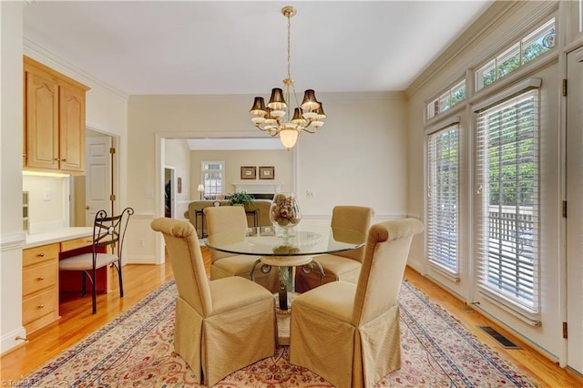 4208 Bitternut Trl, Greensboro, NC 27410 - dining room featuring light wood-style floors, a chandelier, and crown molding
