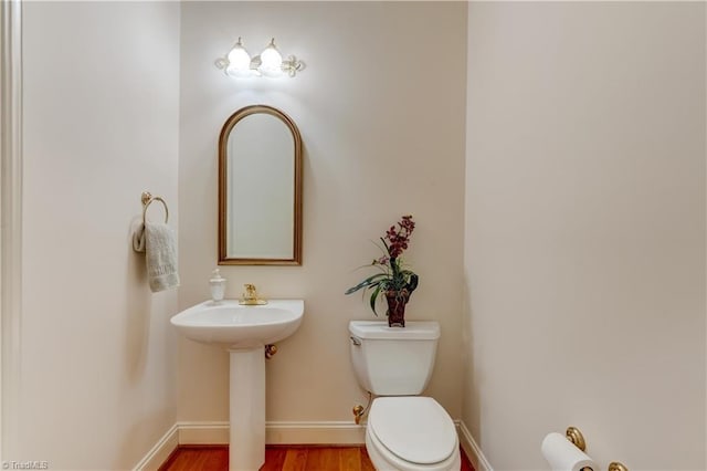 4208 Bitternut Trl, Greensboro, NC 27410 - half bathroom featuring toilet, wood finished floors, baseboards, and a sink