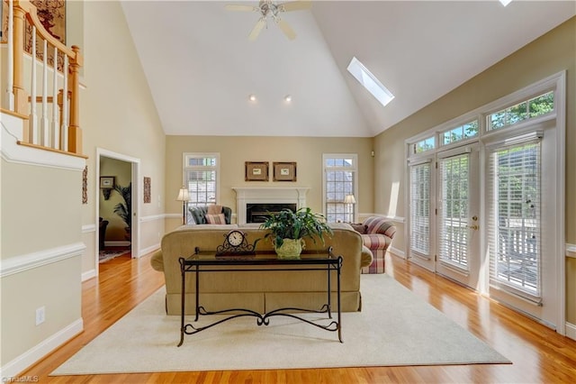 4208 Bitternut Trl, Greensboro, NC 27410 - living room with high vaulted ceiling, a skylight, wood finished floors, a ceiling fan, and a premium fireplace