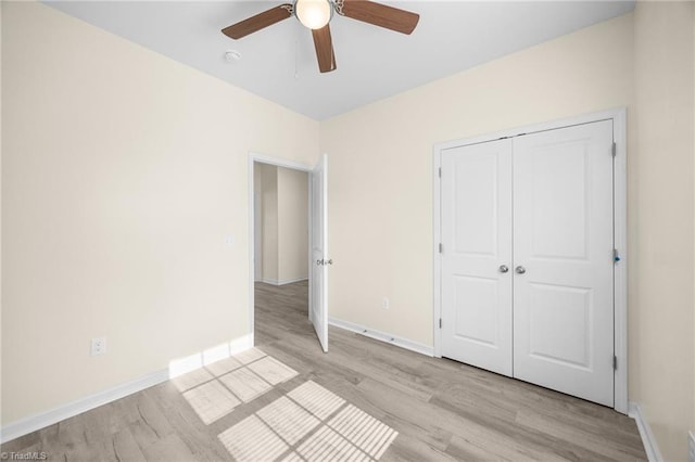 907 Caldwell St, Greensboro, NC 27406 - unfurnished bedroom featuring light wood-style flooring, baseboards, a closet, and ceiling fan