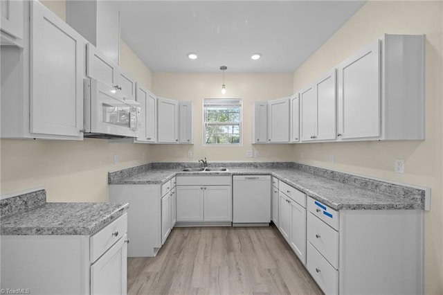 907 Caldwell St, Greensboro, NC 27406 - kitchen featuring white appliances, a sink, light wood-style floors, recessed lighting, and white cabinets
