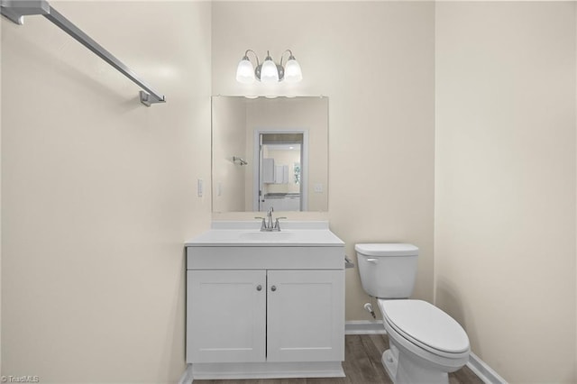 907 Caldwell St, Greensboro, NC 27406 - half bathroom with toilet, wood finished floors, vanity, and baseboards