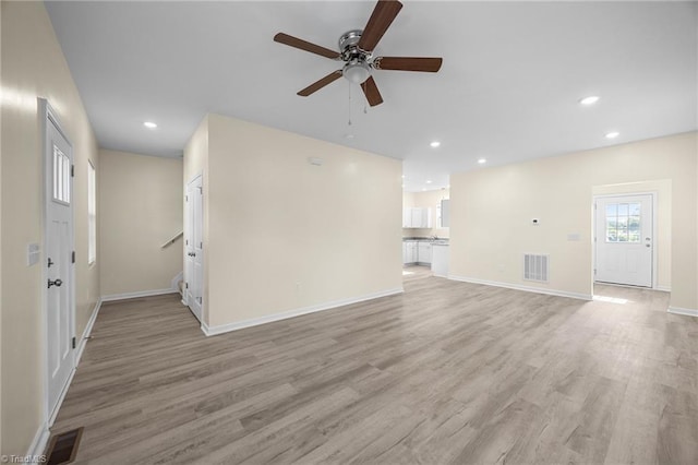 907 Caldwell St, Greensboro, NC 27406 - unfurnished living room with a ceiling fan, light wood-style flooring, recessed lighting, baseboards, and stairs
