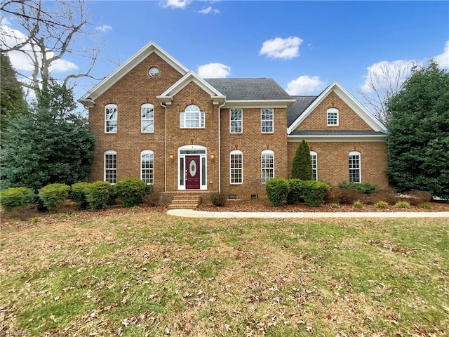 colonial inspired home featuring a front lawn