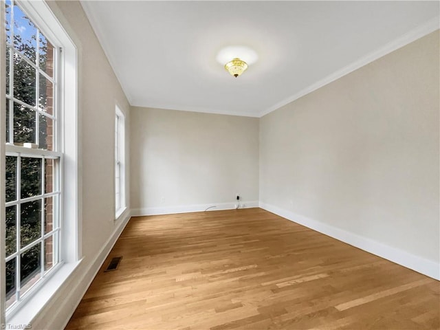 unfurnished room featuring light hardwood / wood-style floors and crown molding