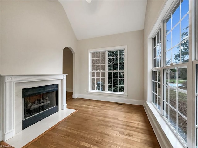 unfurnished living room with light wood-type flooring and lofted ceiling