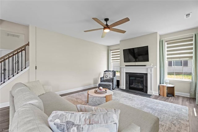 1827 Deveron Ct, Kernersville, NC 27284 - living room with ceiling fan, wood finished floors, a fireplace with flush hearth, and stairs