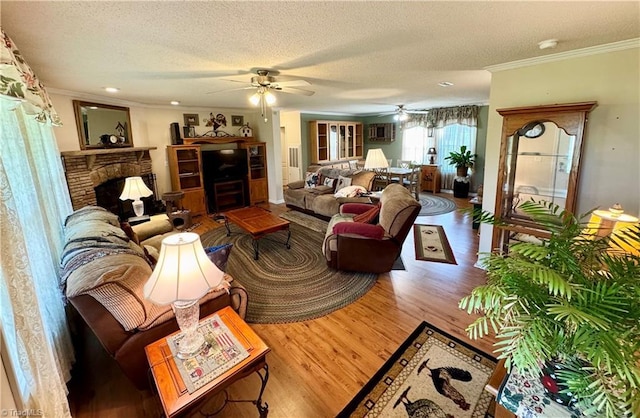 7658 Salem Chapel Rd, Walnut Cove, NC 27052 - living area featuring ornamental molding, wood finished floors, a textured ceiling, a fireplace, and a ceiling fan