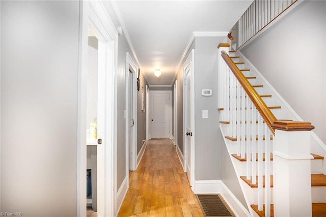 hallway featuring crown molding and light hardwood / wood-style floors