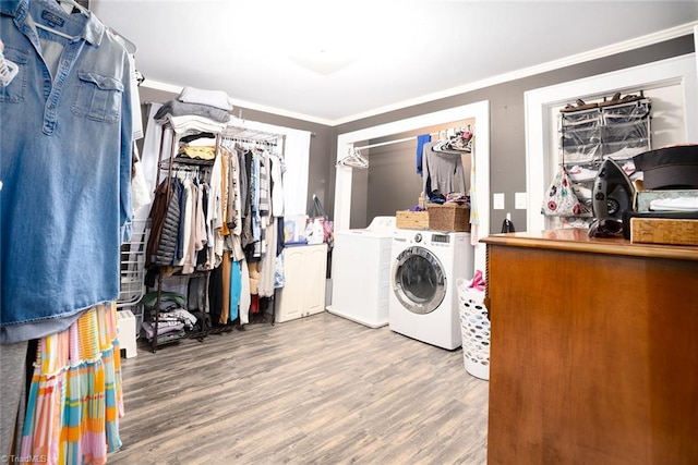 laundry room with ornamental molding, hardwood / wood-style floors, and washer and dryer