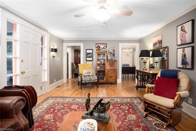 living room with light hardwood / wood-style floors, ceiling fan, and crown molding