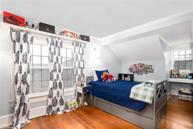 bedroom featuring ornamental molding, wood-type flooring, and lofted ceiling